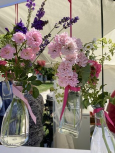 Hängende Glasvasen mit Rosen und Lavendel am Stand der Rosengruppe-Traumfelder