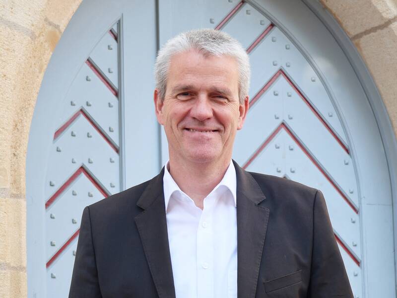 Oberbürgermeister Christof Bolay steht vor dem Propsteigebäude und lächelt in die Kamera