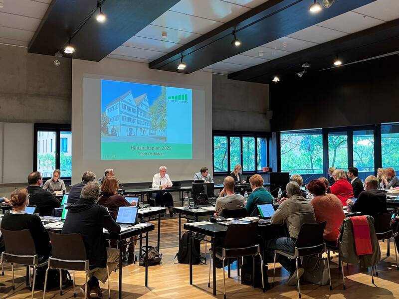 Der Stadthaussaal, in dem die Gemeinderäte sitzen und auf eine Präsentation zum Haushaltsplan 2025 der Stadt Ostfildern sehen.