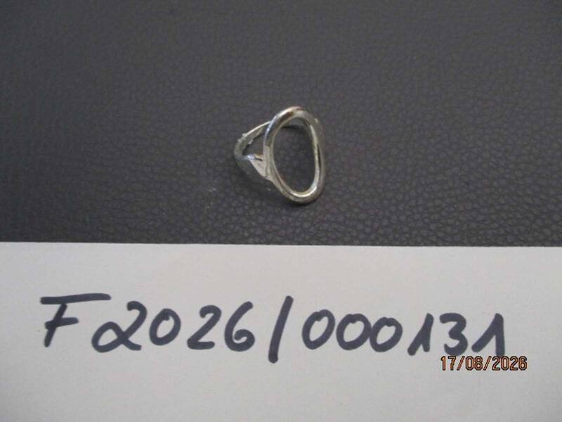 Ein silberner Ring liegt auf einer dunklen Oberfläche, darunter ist eine weiße Karte mit der handgeschriebenen Nummer "F2026/000131" zu sehen. KI-BildBeschreiber