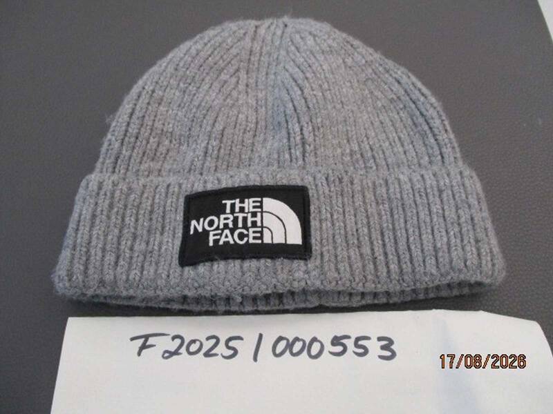 Eine grau Wollmütze mit einem Patch auf dem The North Face steht