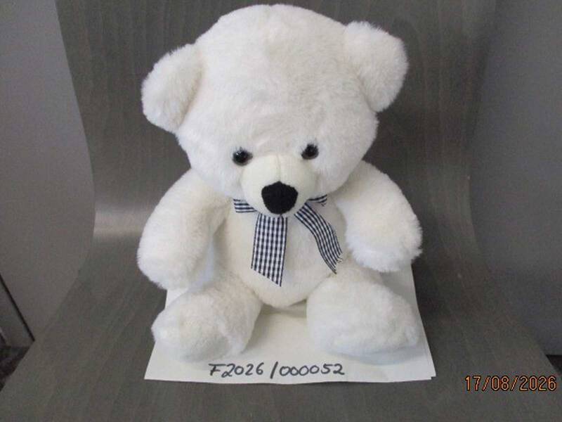 Ein weißer Teddybär mit einer blau-weißen Schleife um den Hals