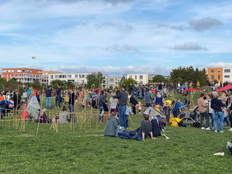 Viele Besucher liegen und stehen auf einer Wiese
