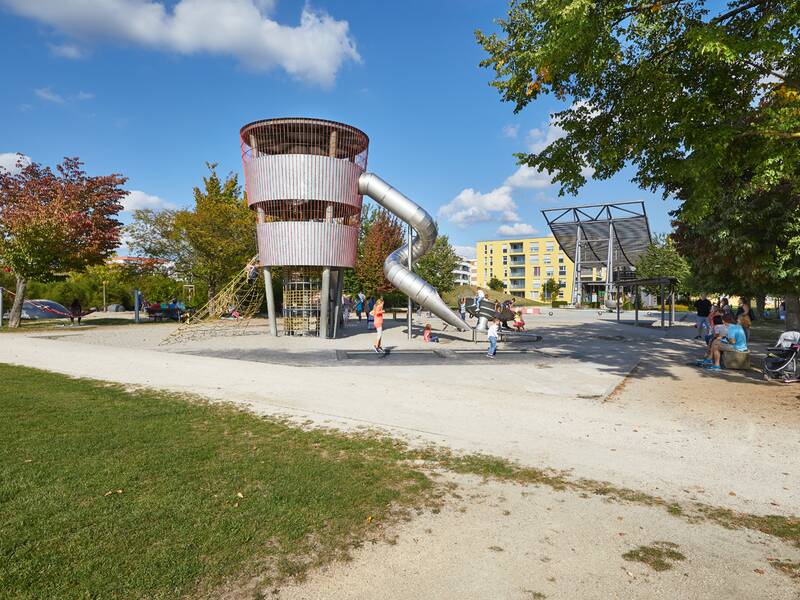 Das Bild zeigt den sogenannten Fliegerspielplatz im Scharnhauser Park an einem sonnigen Tag, der seinen Namen von einem Hubschrauber-Spielgerät hat.