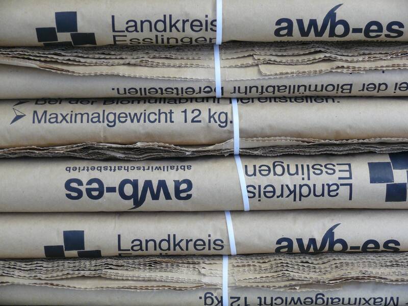 Das Bild zeigt gestapelte, gebündelte Papiertüten mit der Aufschrift "Landkreis Esslingen" und einem maximalen Gewicht von 12 kg. (KI generiert)