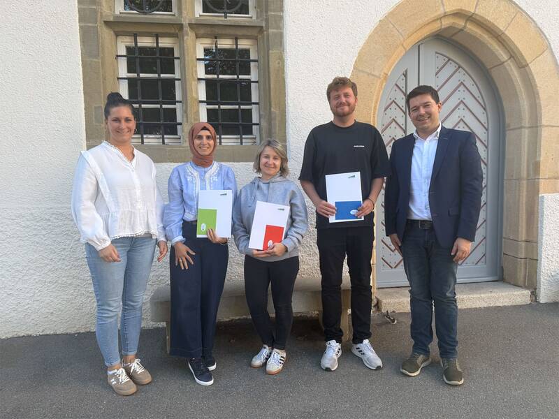 Fünf Personen stehen nebeneinander vor einem Gebäude mit einer weißen Fassade und einer dekorativen Tür, während drei von ihnen Mappen in der Hand halten. (KI generiert)