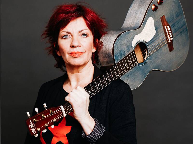 Kabarettistin Dagmar Schönleber hält eine Gitarre in der Hand.