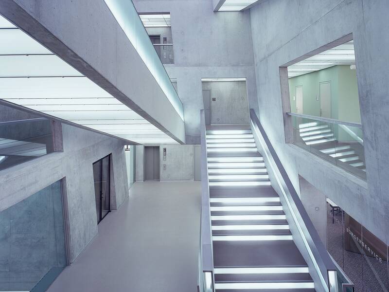 Eine moderne, minimalistische Innentreppe mit beleuchteten Stufen befindet sich im Stadthaus.
