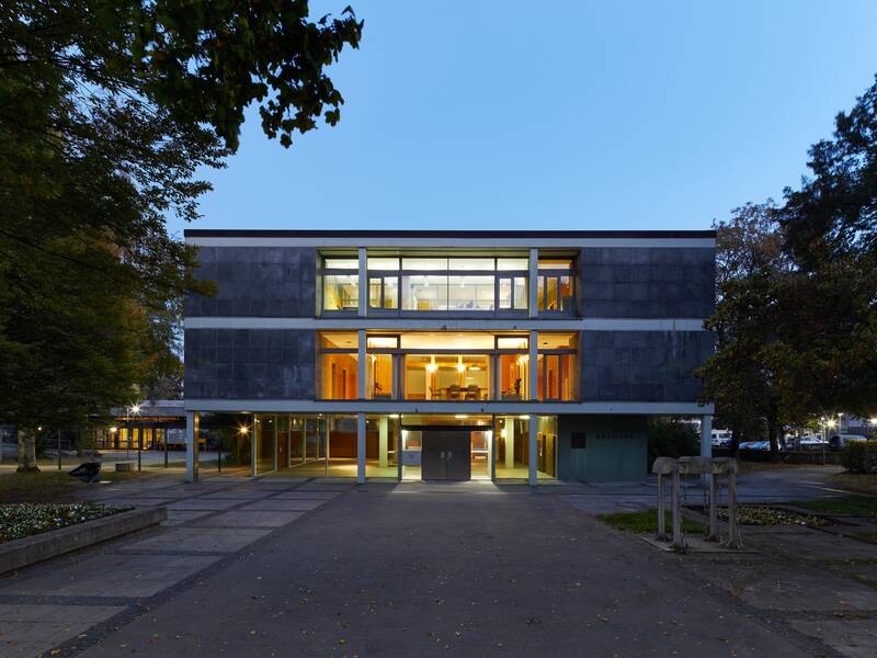 Vorderansicht des Rathauses im Stadtteil Ruit. Die Fenster sind beleuchtet, da die Aufnahme in der Dämmerung gemacht wurde.