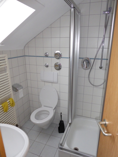 Das Tageslichtbad mit WC im Dachgeschoss ist hell gefliest, verfügt über  eine Dusche.