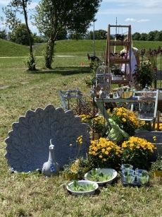 Stand der Gärtnerei Zeh mit blühenden Pflanzen und einem Pfau als Dekoobjekt