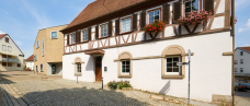 Blick auf das Alte Rathaus in Kemnat mit Fachwerk. Im Hintergrund ist das moderne Gebäude der Bücherei zu sehen.