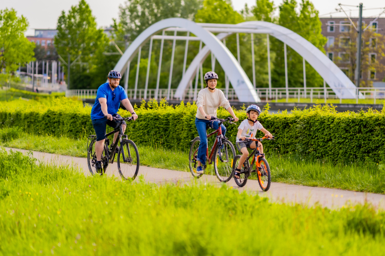 Ein Mann, eine Frau und ein Kind auf dem Fahrrad.
