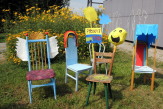 Bunt gestaltete Stühle stehen vor der Kinderaktivwerkstatt